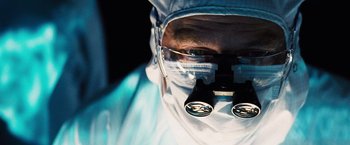 Movie still from “The Island” (2005), directed by Michael Bay – A man wearing a surgical mask and goggles looking at the camera; Extreme Close Up shot, Low angle