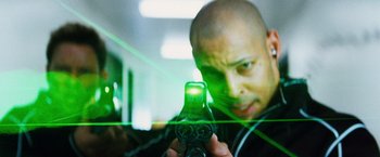 Movie still from “The Island” (2005), directed by Michael Bay – A man holding a remote control in front of a mirror; Close Up shot, Low angle