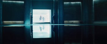 Movie still from “The Island” (2005), directed by Michael Bay – A group of people standing in front of a large window; Extreme Wide shot, Low angle