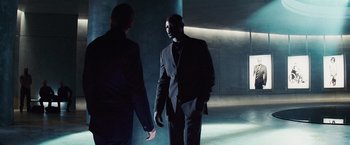 Movie still from “The Island” (2005), directed by Michael Bay – A man in a suit and tie talking to another man in a suit and tie; Medium shot, Low angle