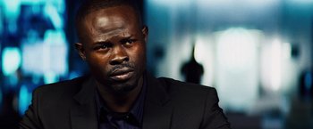 Movie still from “The Island” (2005), directed by Michael Bay – A person wearing a suit and tie; Close Up shot, Over the shoulder angle