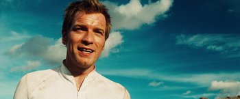 Movie still from “The Island” (2005), directed by Michael Bay – A person smiling with a sky in the background; Close Up shot, Low angle