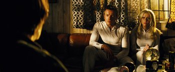 Movie still from “The Island” (2005), directed by Michael Bay – A man sitting on top of a brown leather couch; Medium shot, Low angle