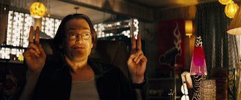 Movie still from “The Island” (2005), directed by Michael Bay – A man sitting in a chair holding up a peace sign; Close Up shot, Low angle