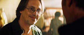 Movie still from “The Island” (2005), directed by Michael Bay – A person wearing glasses and smiling; Close Up shot, Over the shoulder angle