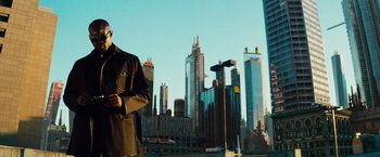 Movie still from “The Island” (2005), directed by Michael Bay – A man standing in front of a city skyline; Medium shot, Low angle