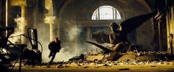 Movie still from “The Island” (2005), directed by Michael Bay – An angel statue sitting on top of a pile of rubble; Wide shot, Low angle