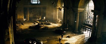 Movie still from “The Island” (2005), directed by Michael Bay – A person walking in a dark room near a building; Extreme Wide shot, High angle