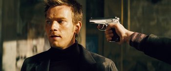 Movie still from “The Island” (2005), directed by Michael Bay – A man is holding a gun up to his face; Close Up shot, Over the shoulder angle