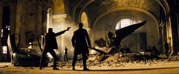 Movie still from “The Island” (2005), directed by Michael Bay – A group of people standing in a room with rubble; Wide shot, Low angle