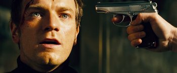 Movie still from “The Island” (2005), directed by Michael Bay – A person holding a gun in their hand; Close Up shot, Low angle