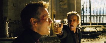 Movie still from “The Island” (2005), directed by Michael Bay – Two men one of whom is holding a gun and the other one is holding a knife in his other hand; Close Up shot, Over the shoulder angle