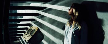 Movie still from “The Island” (2005), directed by Michael Bay – A woman standing in front of a wall with shadows on the wall; Medium shot, Low angle