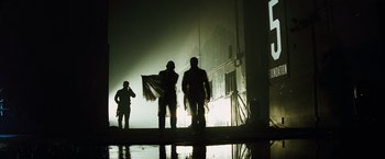 Movie still from “The Island” (2005), directed by Michael Bay – A group of men standing next to each other in the dark; Wide shot, Low angle