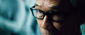 Movie still from “The Island” (2005), directed by Michael Bay – An older man wearing glasses looking at the camera; Extreme Close Up shot, Low angle