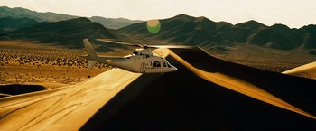 Movie still from “The Island” (2005), directed by Michael Bay – A helicopter is flying over a desert landscape; Extreme Wide shot, High angle