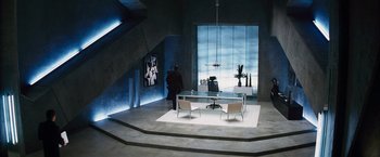 Movie still from “The Island” (2005), directed by Michael Bay – A room that has a table and chairs in it; Wide shot, High angle