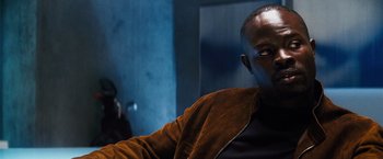 Movie still from “The Island” (2005), directed by Michael Bay – A person sitting in a room; Close Up shot, Low angle