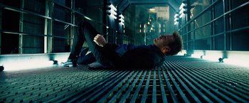 Movie still from “The Island” (2005), directed by Michael Bay – A man laying on the ground in a building; Wide shot, Overhead angle