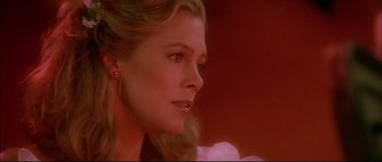 Movie still from “The Jewel of the Nile” (1985), directed by Lewis Teague – A woman's face in a red room; Close Up shot, Over the shoulder angle