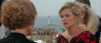 Movie still from “The Jewel of the Nile” (1985), directed by Lewis Teague – Two people are talking in front of the ocean; Close Up shot, Over the shoulder angle