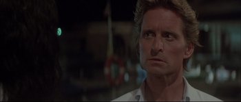 Movie still from “The Jewel of the Nile” (1985), directed by Lewis Teague – A person wearing a white shirt; Close Up shot, Over the shoulder angle