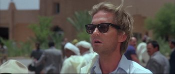Movie still from “The Jewel of the Nile” (1985), directed by Lewis Teague – A person wearing sunglasses; Close Up shot, Low angle