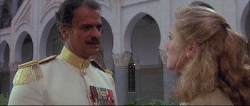 Movie still from “The Jewel of the Nile” (1985), directed by Lewis Teague – A man and a woman are standing in a courtyard; Medium shot, Over the shoulder angle