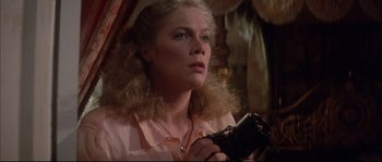 Movie still from “The Jewel of the Nile” (1985), directed by Lewis Teague – A woman holding a video camera in her hands; Close Up shot, Low angle