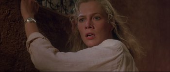 Movie still from “The Jewel of the Nile” (1985), directed by Lewis Teague – A person with long blonde hair; Close Up shot, Low angle