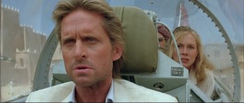 Movie still from “The Jewel of the Nile” (1985), directed by Lewis Teague – A person with long blonde hair; Close Up shot, Over the shoulder angle