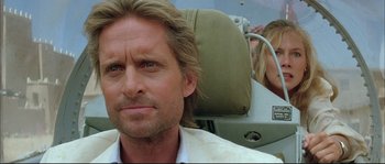 Movie still from “The Jewel of the Nile” (1985), directed by Lewis Teague – A person sitting in a chair; Close Up shot, Over the shoulder angle