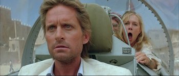 Movie still from “The Jewel of the Nile” (1985), directed by Lewis Teague – A man and a woman sitting in an airplane seat; Close Up shot, Low angle