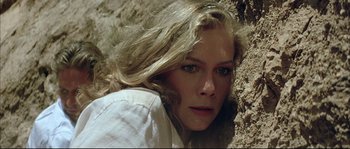 Movie still from “The Jewel of the Nile” (1985), directed by Lewis Teague – A person with long hair; Close Up shot, High angle