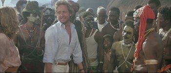 Movie still from “The Jewel of the Nile” (1985), directed by Lewis Teague – A group of men standing next to each other; Medium shot, Over the shoulder angle