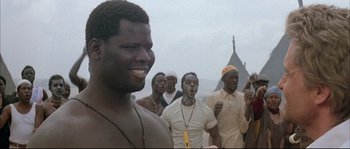 Movie still from “The Jewel of the Nile” (1985), directed by Lewis Teague – A group of men standing next to each other; Close Up shot, Over the shoulder angle