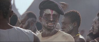 Movie still from “The Jewel of the Nile” (1985), directed by Lewis Teague – A group of men with faces painted in different colors; Close Up shot, Low angle