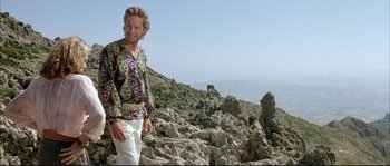 Movie still from “The Jewel of the Nile” (1985), directed by Lewis Teague – A man standing on top of a rocky hill; Medium shot, Low angle