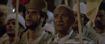 Movie still from “The Jewel of the Nile” (1985), directed by Lewis Teague – A man with a beard and a hat is next to another man with a beard; Close Up shot, Low angle
