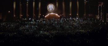 Movie still from “The Jewel of the Nile” (1985), directed by Lewis Teague – A crowd of people standing in front of an illuminated sign at night; Extreme Wide shot, High angle