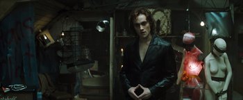 Movie still from “Queen of the Damned” (2002), directed by Michael Rymer – A man in a black jacket standing in a room; Medium shot, Over the shoulder angle