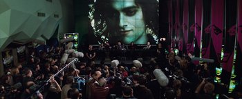Movie still from “Queen of the Damned” (2002), directed by Michael Rymer – A crowd of people sitting in front of a large screen; Wide shot, Over the shoulder angle