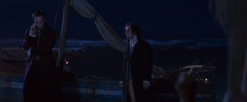 Movie still from “Queen of the Damned” (2002), directed by Michael Rymer – A man standing in front of a boat at night; Medium shot, Over the shoulder angle