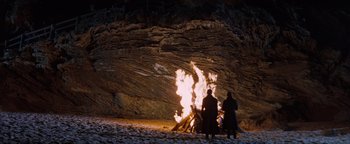 Movie still from “Queen of the Damned” (2002), directed by Michael Rymer – Two people standing in front of a bonfire; Wide shot, High angle