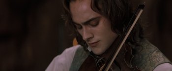 Movie still from “Queen of the Damned” (2002), directed by Michael Rymer – A person holding a violin; Close Up shot, Over the shoulder angle
