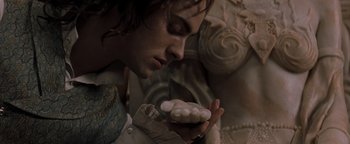 Movie still from “Queen of the Damned” (2002), directed by Michael Rymer – A man holding a bunch of candles in his hands; Close Up shot, Low angle