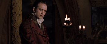 Movie still from “Queen of the Damned” (2002), directed by Michael Rymer – A man standing in front of a fireplace; Medium shot, Low angle