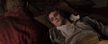 Movie still from “Queen of the Damned” (2002), directed by Michael Rymer – A man laying on the ground looking at the camera; Medium shot, High angle