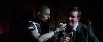 Two men sitting at a table with a glass of wine