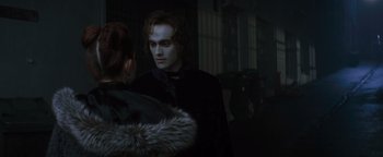 Movie still from “Queen of the Damned” (2002), directed by Michael Rymer – A man and a woman dressed up in a dark room; Medium shot, Over the shoulder angle